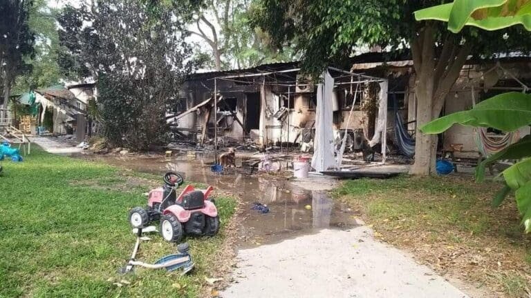 Burned remains of a house in Israel, post-Hamas attack, with children's toys in the foreground.