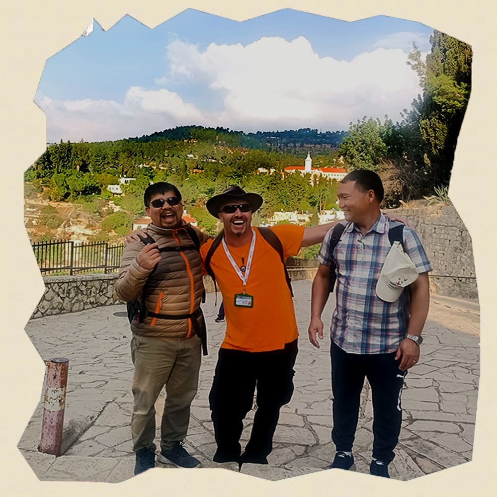 Enthusiastic tour guide Shay Figenbaum with tourists in Jerusalem, Israel, sharing smiles and stories.