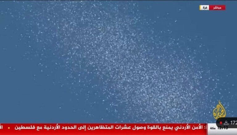 A screenshot of a TV broadcast showing numerous white dots scattered across a blue background.