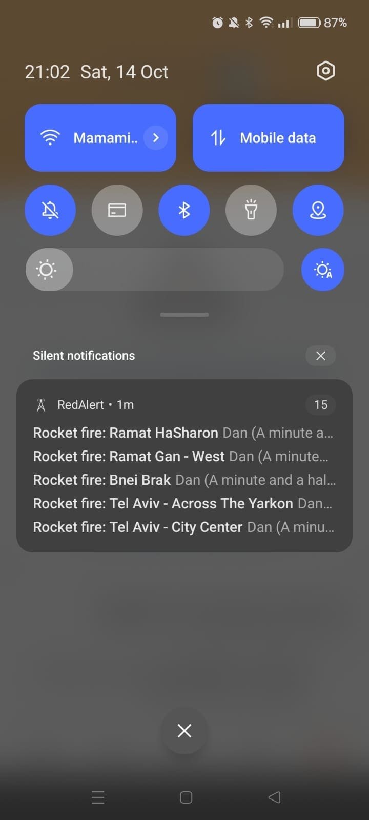 Mobile phone notifications indicating rocket fire in various locations in Israel.