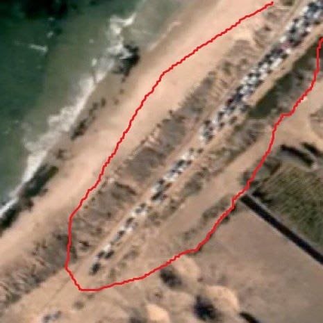 Satellite image showing a line of cars in Gaza outlined by a red border.