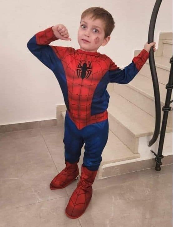 A young boy dressed as a superhero, posing with innocence and strength.