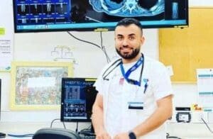 Dr. Tarek Abu Arar, a volunteer Muslim doctor, stands in an emergency room with medical equipment in the background, after surviving a hostage situation by Hamas terrorists.