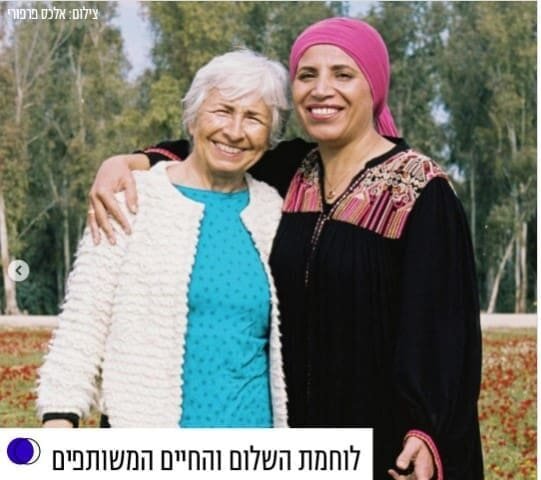 An image of Vivian Silver and an Arab woman smiling together.