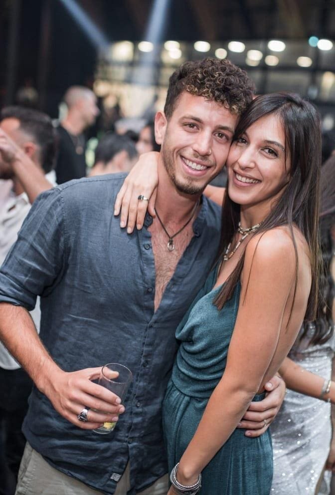 A smiling young man and woman embracing each other at a party, unaware of the tragedy that will soon befall them.